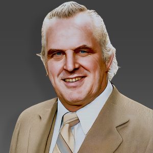 Eddie Graham, legendary promoter and wrestler of Championship Wrestling from Florida, wearing a suit and tie, symbolizing the golden era of Florida wrestling.