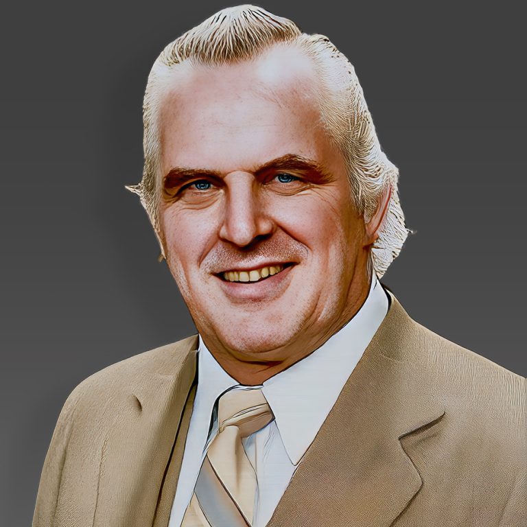 Eddie Graham, legendary promoter and wrestler of Championship Wrestling from Florida, wearing a suit and tie, symbolizing the golden era of Florida wrestling.